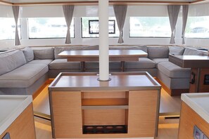 Ein modernes Interieur mit einer Couch, einem Esstisch und einer zentralen Säule.