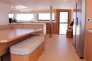 Eine moderne Küche mit integriertem Kühlschrank, einem Essbereich mit einer Bank und einem Fenster, das natürliches Licht hereinlässt.