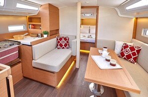 Ein kompaktes Wohnmobil-Interieur mit Küchenzeile, Essbereich und Schlafkoje.