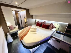 Ein modernes Hotelzimmer mit einem großen Bett, Nachttischen und einem fest eingebauten Schreibtisch.