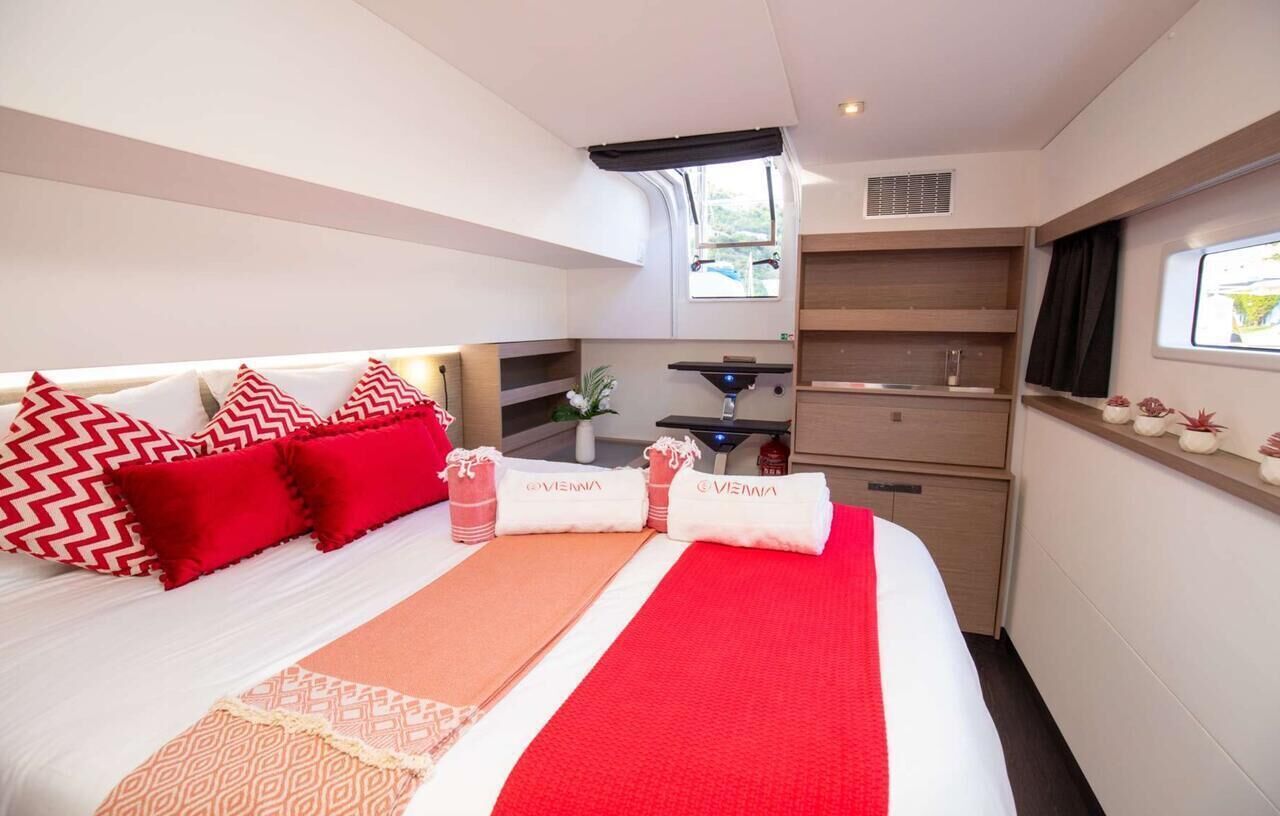 A hotel room with a bed, a small kitchenette, and a window.
