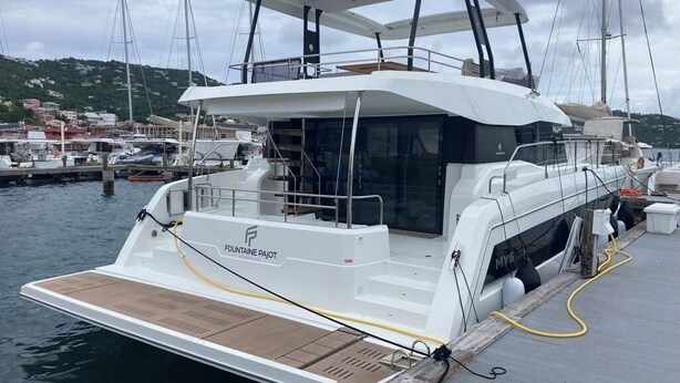 A white yacht docked at a marina with a covered deck, a name 'FONTAINE PAJOT' on the side, and a wooden deck area. - Sun-Kissed Sailing: A Caribbean Beach Experience from Islas Vírgenes de Estados Unidos, Santo Tomás (St Thomas)