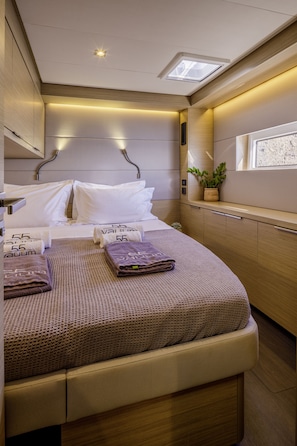 A compact bedroom with a bed, bedside tables, a window, and a skylight. - Sun-Kissed Sailing Adventure in the Saronic Islands (Elliniko)