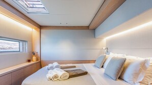 A modern hotel room with a large bed, a window with a view, and a skylight. - Sun-Kissed Sailing Adventure in the Saronic Islands (Elliniko)