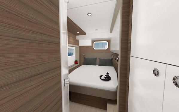 A compact bedroom with a bed, a small window, and a bedside table.