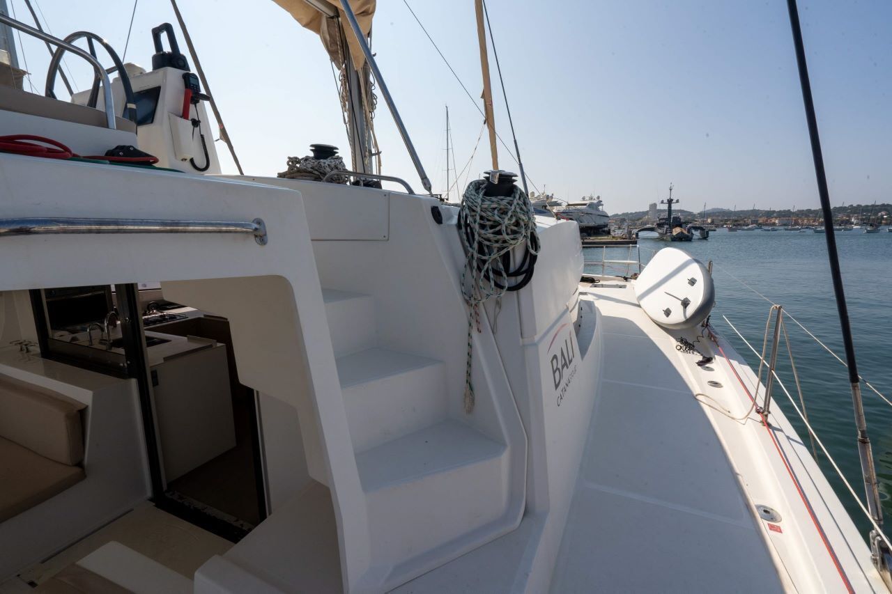 Cubierta de barco con una cabina blanca, un timón y un cabrestante.