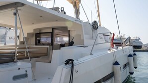 Un yacht doté d’un pont couvert, d’un espace salon et offrant une vue sur le port de plaisance.