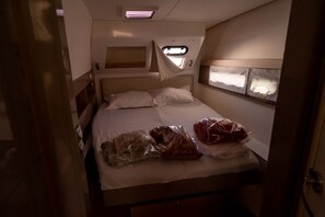 A small, compact bedroom with a single bed, a window, and a skylight. - Sun-Kissed Sailing Adventure in Provence-Alpes-Côte d'Azur (Saint-Mandrier-sur-Mer)
