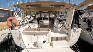 Le pont d’un bateau, équipé d’un volant, d’une bouée de sauvetage et de divers instruments de navigation.
