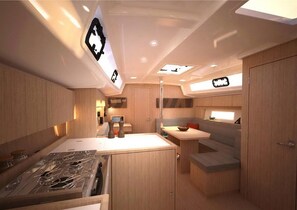 A compact kitchen with a stove, sink, and a small seating area. - Sun-Kissed Sailing Adventure in Antiguo Puerto de La Rochelle (La Rochelle)