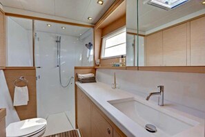 A modern bathroom with a shower, toilet, and sink.