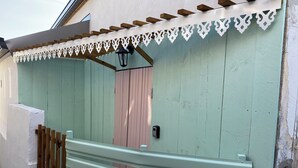 Een gebouw met een groene gevel, een houten omheining en witte decoratieve details.