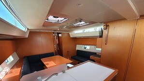 A compact interior with a kitchenette, a dining area, and a seating space. - Sun-Kissed Sailing Adventure in Islas Sarónicas (Laurium)
