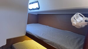 Un lit superposé avec une tête de lit, une fenêtre et un objet blanc sur le côté droit.