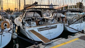 Un puerto deportivo con varios veleros amarrados, incluyendo un barco llamado 'MARINA STAR'.