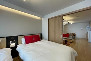 A hotel room with a bed, bedside table, and a view into the dining area. - SEED Tanimachi 6-chome (Osaka)