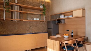 A modern kitchen with wooden cabinetry, stainless steel appliances, and a blue countertop. - Ismini House (Chania)