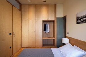 A bedroom with a bed, a wardrobe, a hanging rack, and a lamp. - Ismini House (Chania)