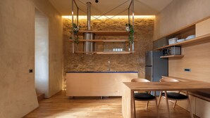 A modern kitchen with a wooden table, chairs, and built-in appliances. - Ismini House (Chania)