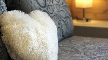 Ein Sofa mit einem gemusterten Kissen und einem flauschigen weißen Kopfkissen.