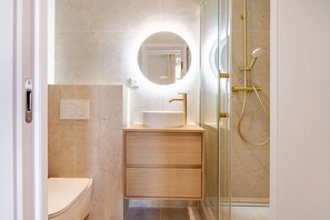 A bathroom with a toilet, a sink with a mirror, and a shower. - Cordeliers 2 Luxury Bedrooms - Rue de la Bourse (Lyon)