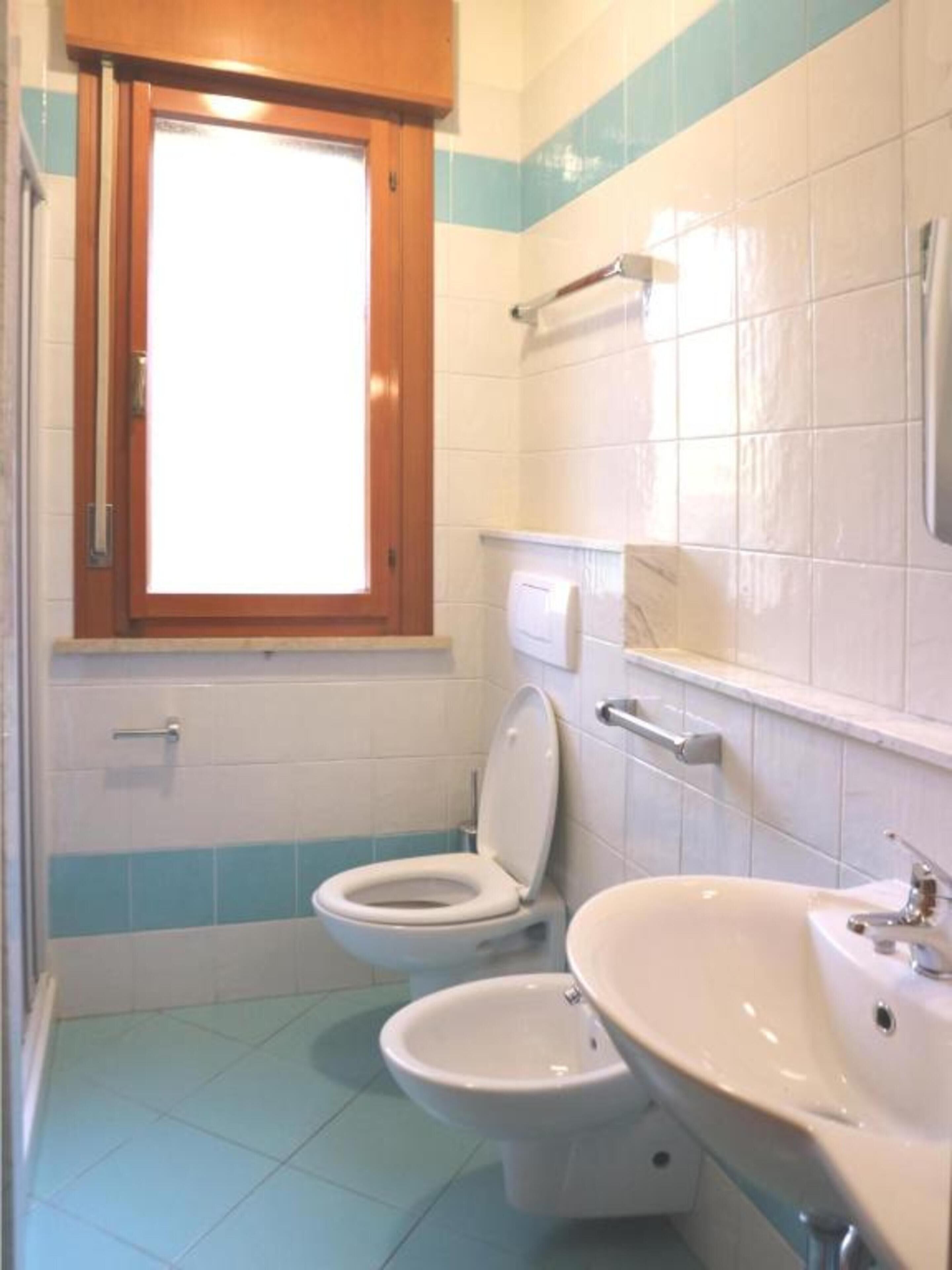 A bathroom with a toilet, bidet, and sink.