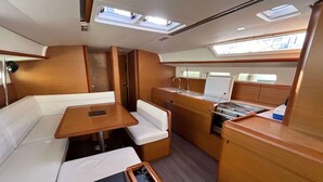 A compact interior with a dining area, kitchenette, and seating. - Sun-Kissed Sailing Adventure in the Saronic Islands (Laurium)