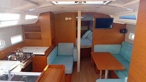 Ein kompaktes Wohnmobil-Interieur mit Küchenzeile, Essbereich und Schlafkoje.