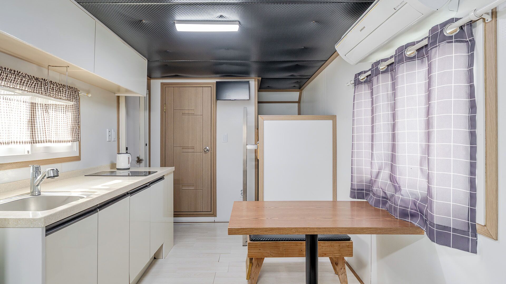 A compact kitchen with a sink, countertop, and a table.
