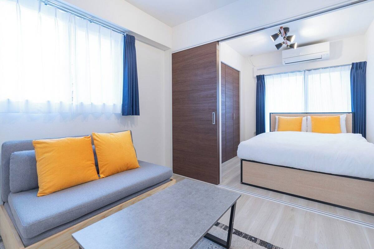 A hotel room with a sofa, bed, wardrobe, and a small table.