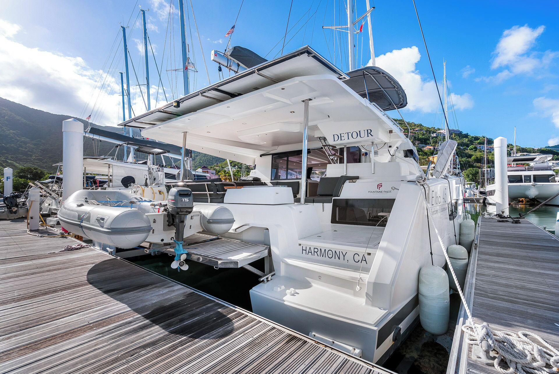 A yacht named 'DETOUR' docked at a marina with a view of the surrounding area.