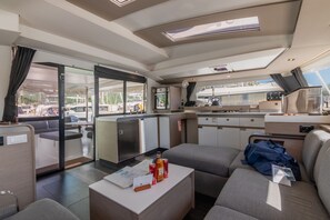 Ein kompakter, moderner Innenraum mit Küchenzeile, Sitzbereich und großen Fenstern mit Blick auf den Hafen.