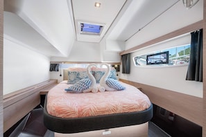 Une chambre à coucher avec un lit, une lucarne, une fenêtre et une vue sur la mer.