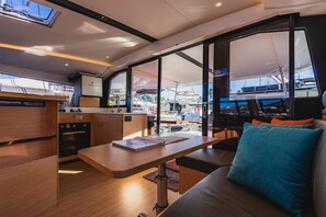 A modern interior with a kitchen, dining area, and a large window offering a view of the marina. - Caribbean Dream: Sun-soaked Sailing Adventure from Tortola, Islas Vírgenes Británicas (Road Town)