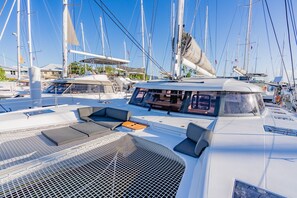 Ein Yachthafen mit mehreren angestaubten Segelbooten, mit einer Steuerungseinheit inklusive Sitzgelegenheiten und einem Metallgrill.