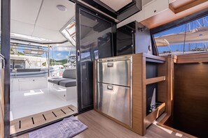 A compact galley with a stainless steel refrigerator, a sink, and a small countertop.