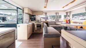Ein kompaktes Wohnmobil-Interieur mit Küchenzeile, einer Sitzecke und Blick auf den Hafen.