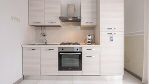 Een moderne keuken met een inbouwoven, een roestvrijstalen afzuigkap en lichte kasten.