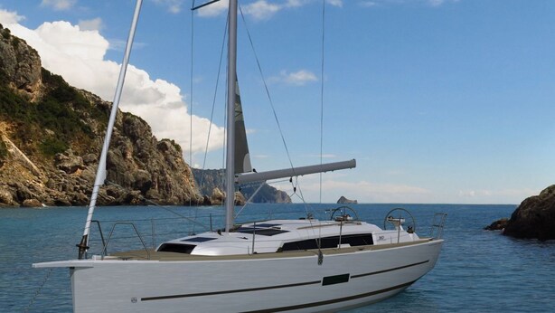 Un velero fondeado cerca de acantilados rocosos bajo cielos despejados.