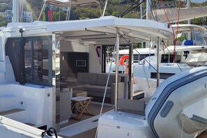 Eine Yacht mit offener Deckfläche, einer Sitzecke und einem kleinen Tisch.