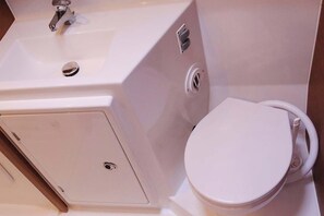 Ein Badezimmer mit Waschbecken, Toilette und Duschbereich.