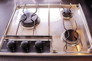 A gas stove with four burners and a control panel.