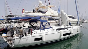 A yacht docked at a marina with multiple boats, a clear sky, and a calm sea. - Sun-Kissed Sailing Adventure in the Saronic Islands (Elliniko)