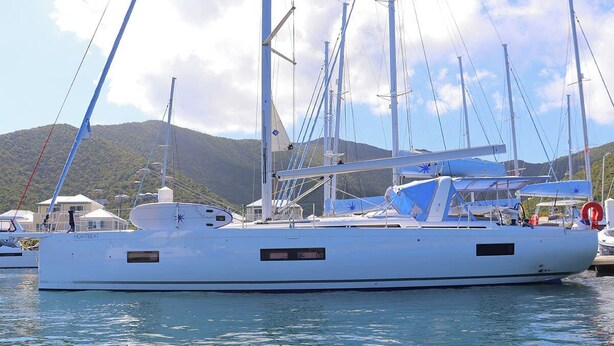 Un yacht blanc était amarré dans une marina, avec une chaîne de montagnes en toile de fond.