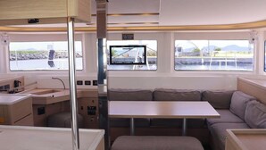 Un interior moderno con comedor, asientos y vistas al agua.