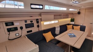 Un interior pequeño con un panel de control, zona de estar y una mesa con una revista.