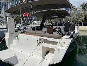 A boat with a covered deck, seating area, and a control station.
