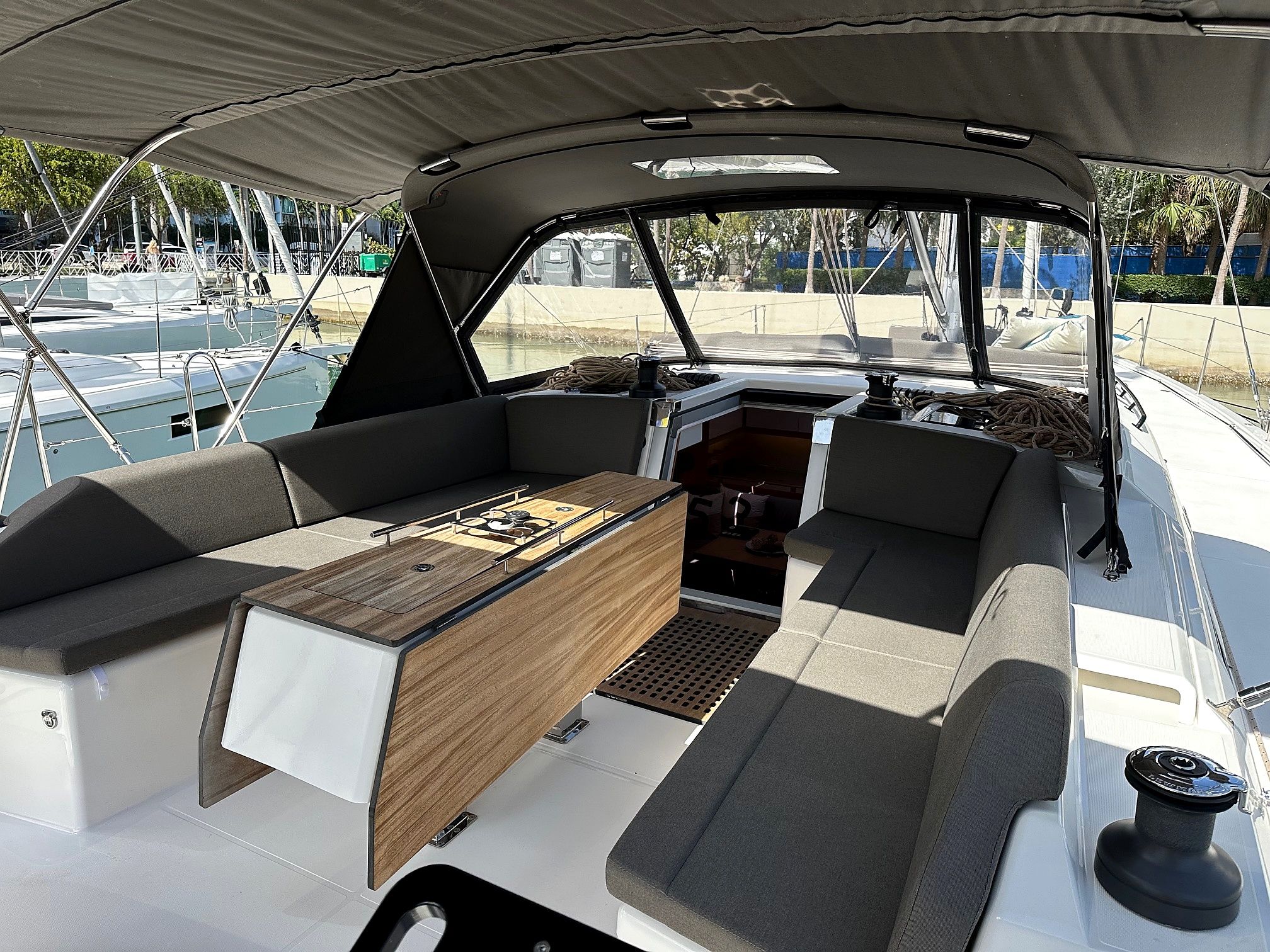 A boat's interior with a central table, cushioned seating, and a canopy overhead.