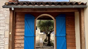 A wooden archway with blue shutters, a stone pathway, and a tree in the background. - Porte Bleue - perfect for group holidays or wedding guests (Eymet)