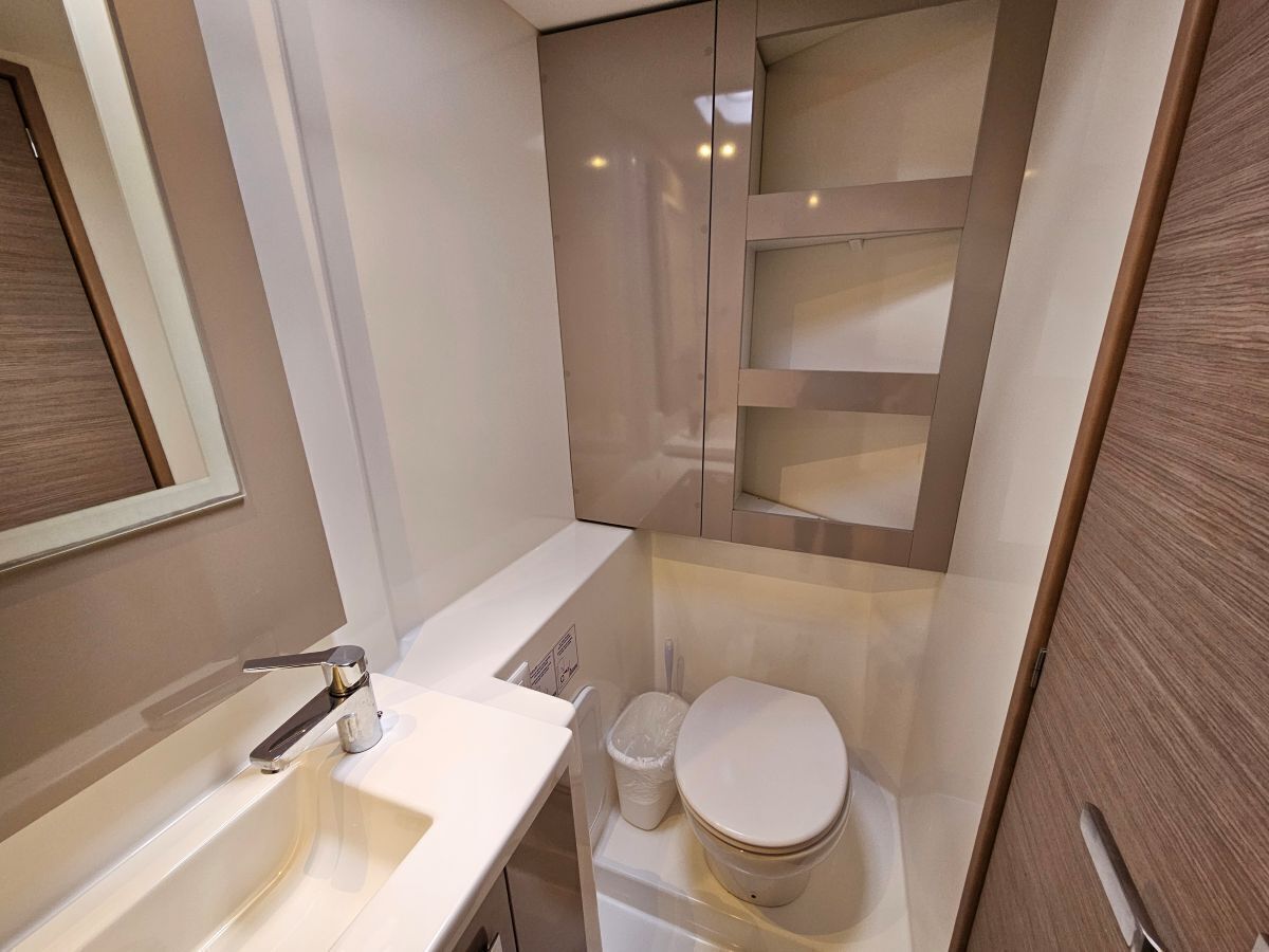 Een kleine badkamer met een wastafel, toilet en spiegel.